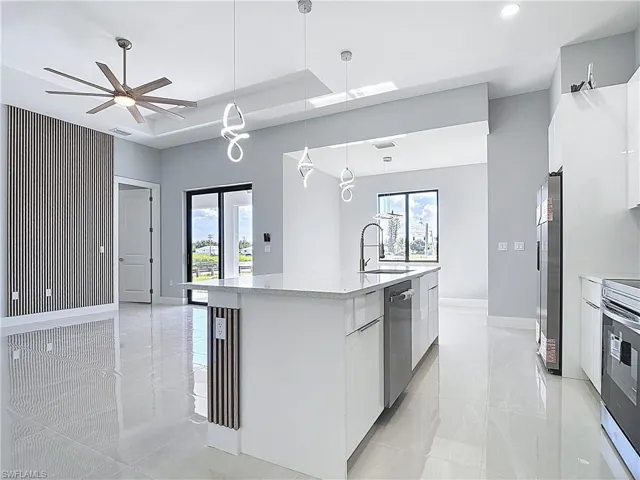 Kitchen featuring modern cabinets, white cabinets, and light stone counters
