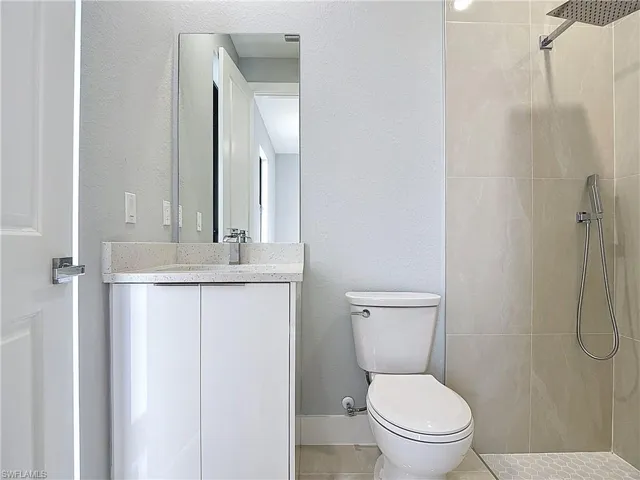Full bath with vanity and tiled shower