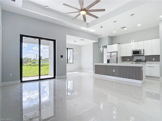 Kitchen featuring light countertops, white cabinetry, modern cabinets, a kitchen island with sink, and stainless steel appliances