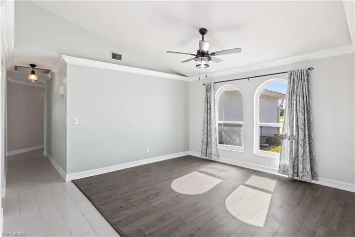dining room featuring hardwood / wood-style floors, ceiling fan, crown molding, and vaulted ceiling