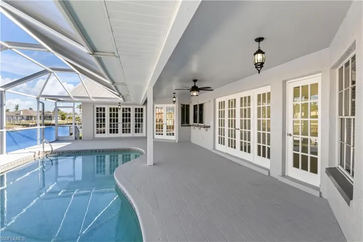 View of swimming pool with a patio area, french doors, and a water view