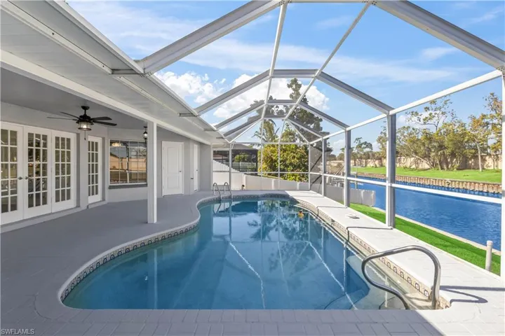 View of swimming pool with a lanai, ceiling fan, french doors, and a patio