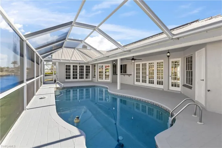 View of swimming pool featuring a lanai, a patio, and french doors