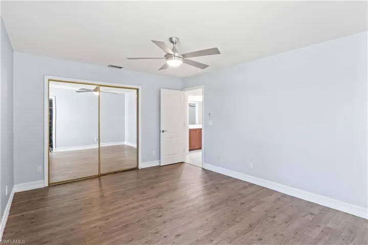 Unfurnished bedroom featuring hardwood / wood-style flooring, ceiling fan, and a closet