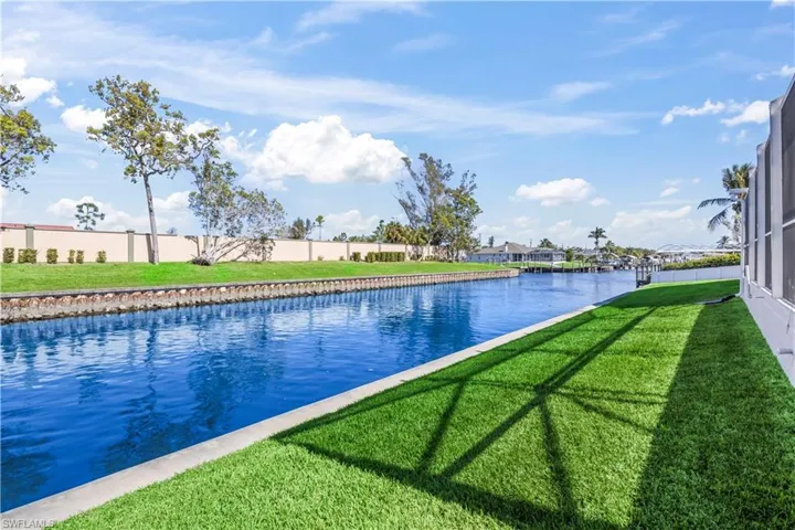 View of pool featuring a lawn and a water view