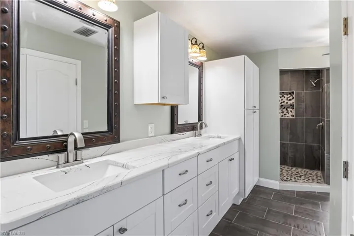 Bathroom featuring vanity and tiled shower