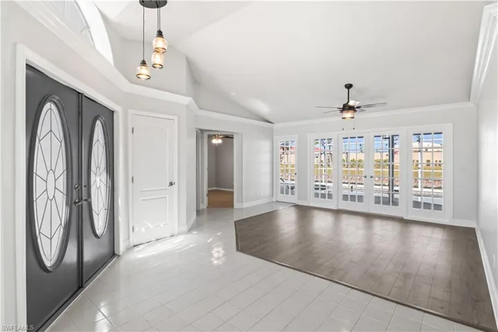 Entryway featuring ceiling fan, crown molding, high vaulted ceiling, and light hardwood / wood-style flooring