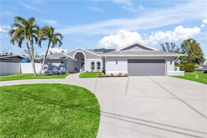 Single story home with a garage and a front lawn