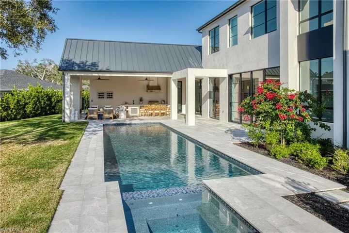 View of pool with a yard, a patio, a pool with connected hot tub, a ceiling fan, and an outdoor living space