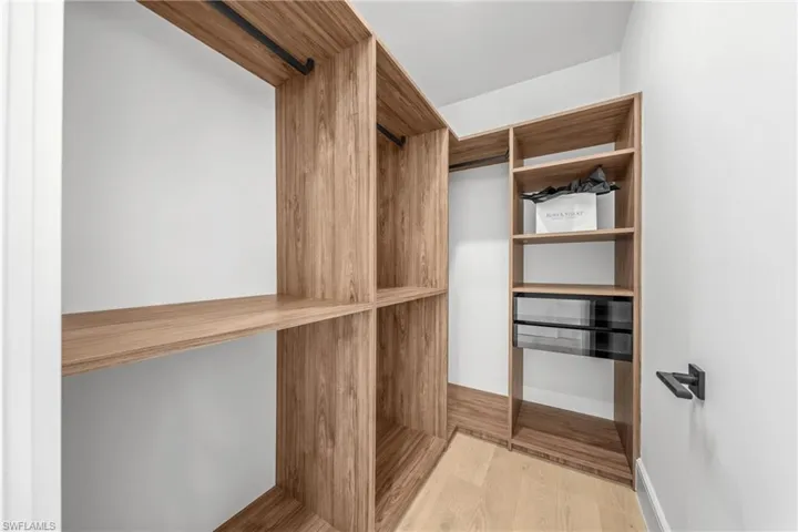 Spacious closet with light wood-style flooring