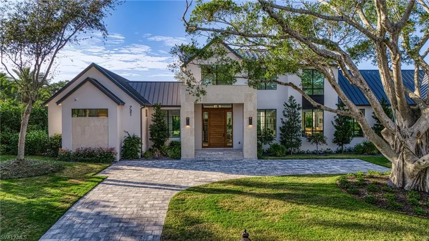 View of front of home with a front yard, a standing seam roof, metal roof, and stucco siding