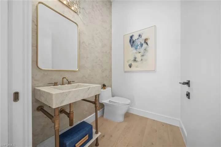 Bathroom featuring baseboards, toilet, and wood finished floors