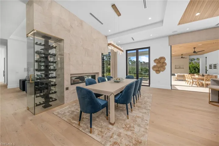 Dining room with light wood-type flooring, a healthy amount of sunlight, a fireplace, and recessed lighting
