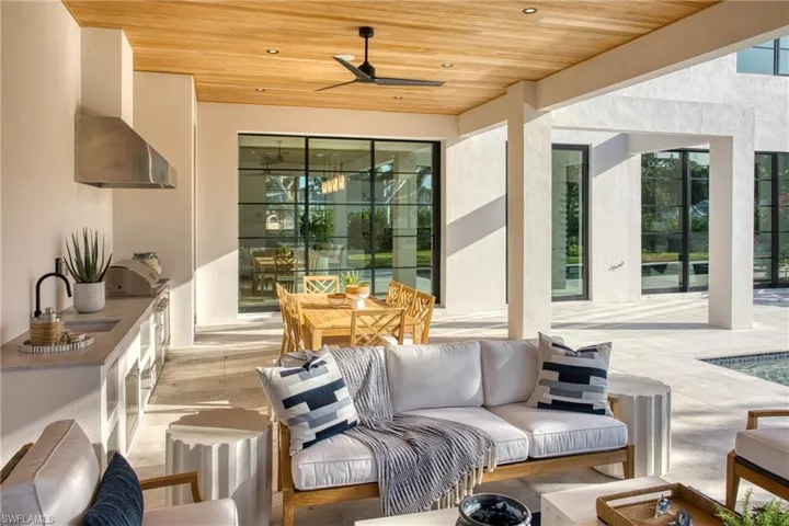 View of patio with ceiling fan, an outdoor hangout area, an outdoor kitchen, and a sink