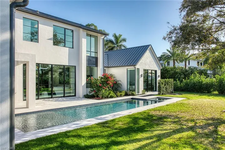 Rear view of property with metal roof, a yard, stucco siding, a standing seam roof, and a patio area