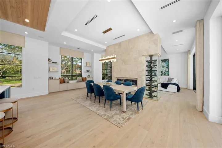 Dining room featuring light wood-type flooring, visible vents, and a fireplace