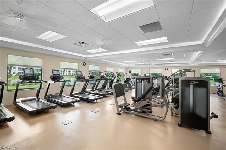 Exercise room with a ceiling fan and a paneled ceiling