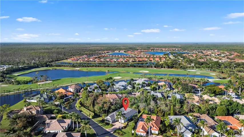 Aerial view of property and surrounding area featuring nearby suburban area, a golf club, and a large body of water