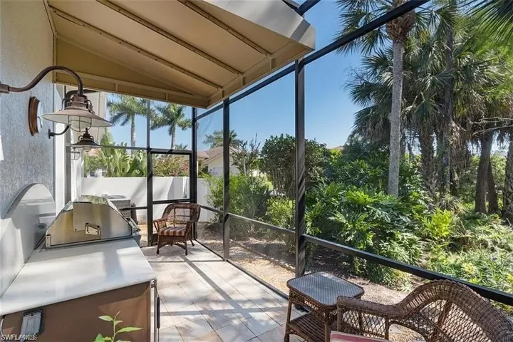 Sunroom featuring lofted ceiling, plenty of natural light, and area for grilling