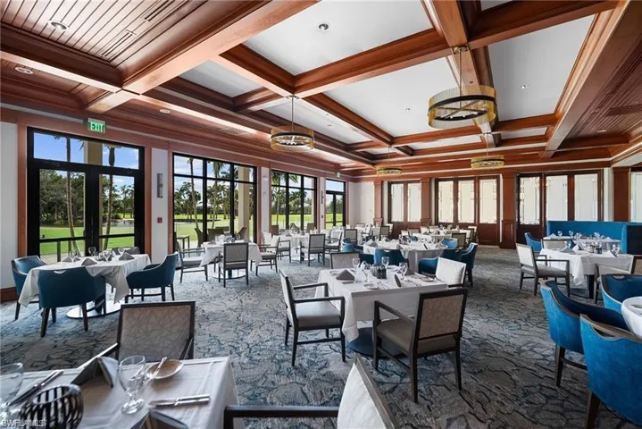 Dining area with coffered ceiling, beamed ceiling, dark colored carpet, healthy amount of natural light, and crown molding