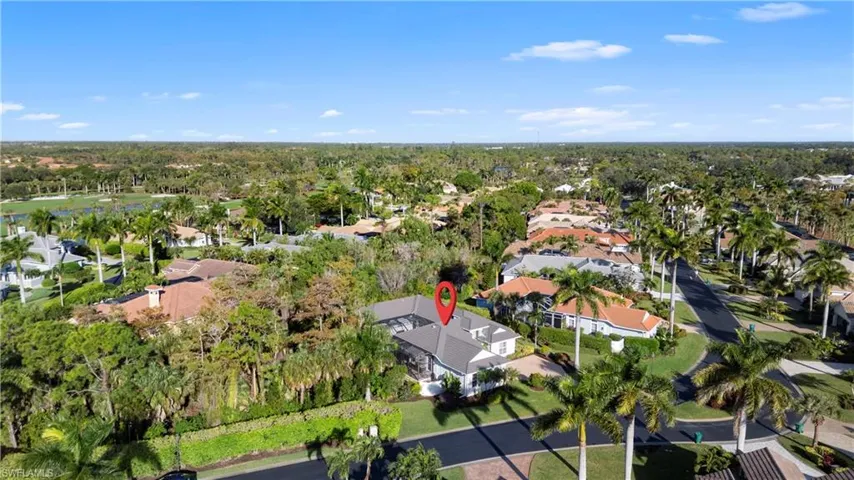 Aerial view of property's location featuring nearby suburban area and a tree filled landscape
