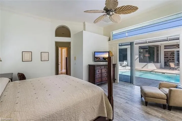 Bedroom featuring wood finished floors, access to outside, a ceiling fan, and crown molding