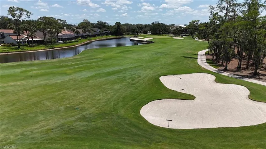 View of home's community featuring golf course view, a water view, and a lawn