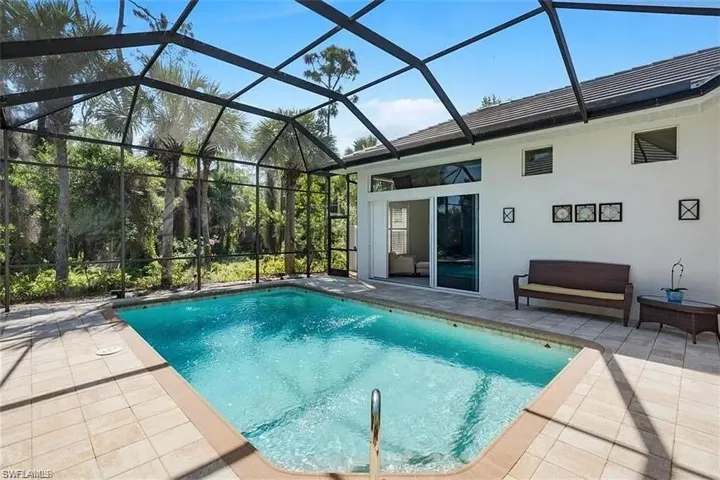Swimming pool with a patio, glass enclosure, and a sunroom