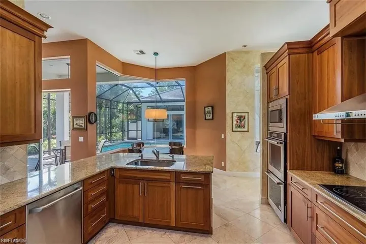 Kitchen featuring tasteful backsplash, brown cabinetry, and stainless steel appliances