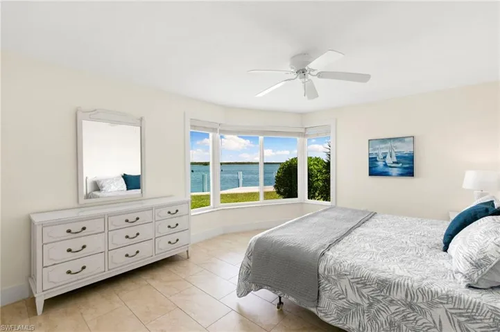 Bedroom featuring a water view and ceiling fan