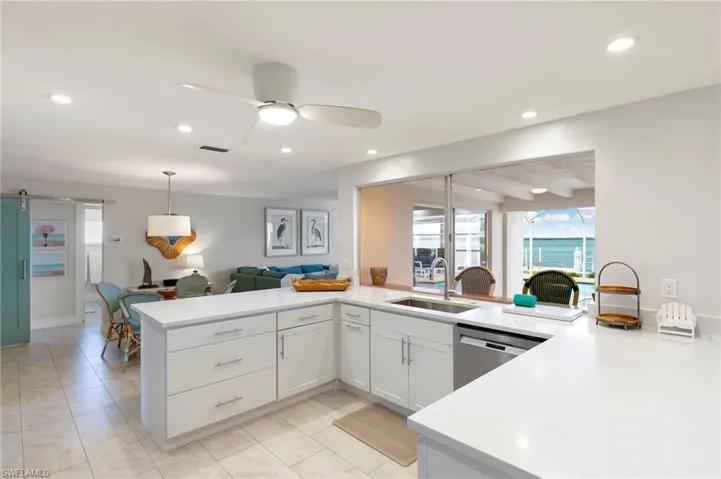 Kitchen featuring plenty of natural light, ceiling fan, sink, and beamed ceiling