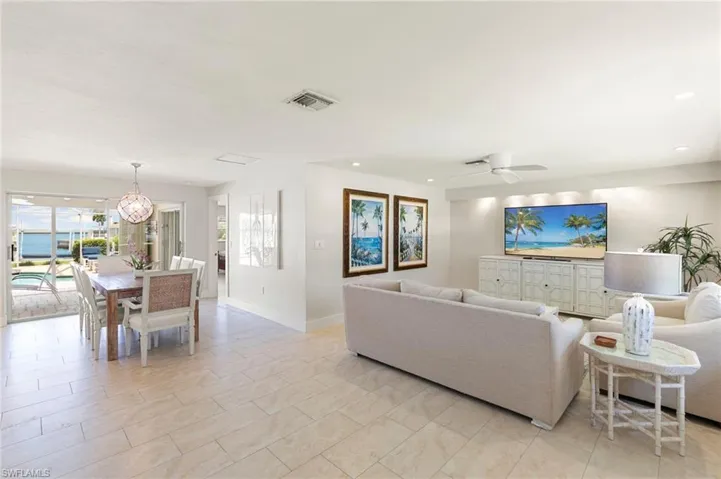 Living room with ceiling fan with notable chandelier