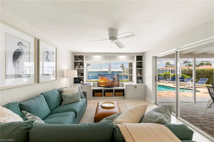 Living room featuring built in features and ceiling fan