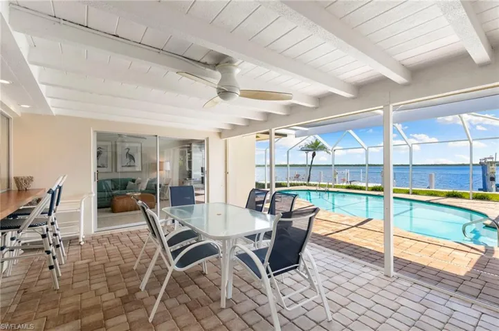 View of patio / terrace featuring a water view, ceiling fan, and a lanai
