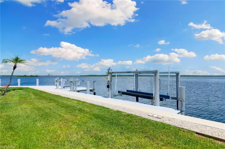 Dock area featuring a water view and a lawn