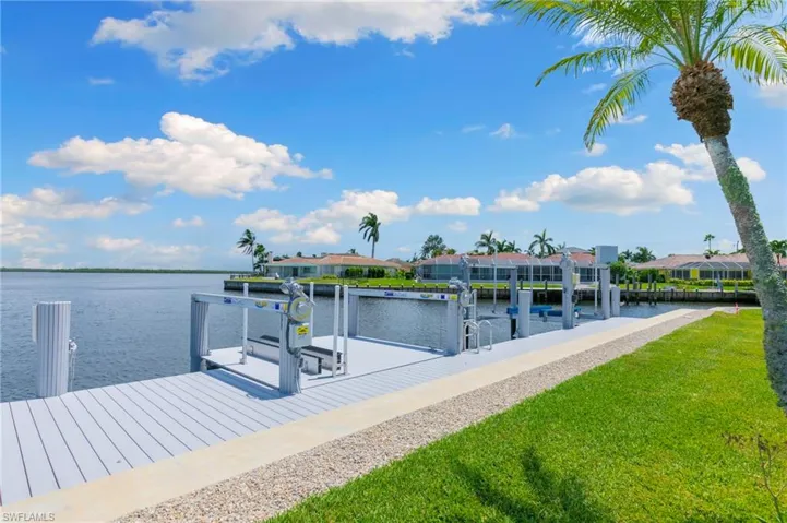 View of dock with a water view and a yard