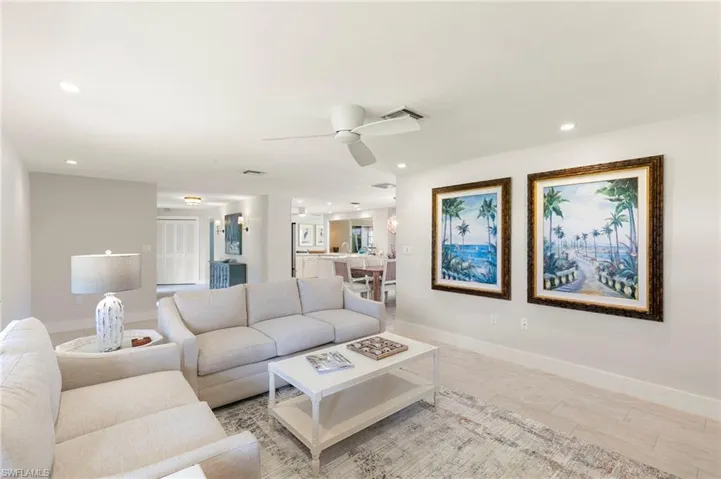 Living room with ceiling fan and light hardwood / wood-style floors