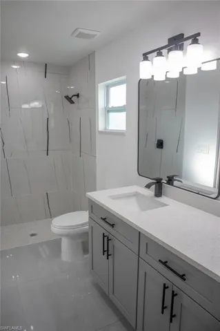 Full bathroom featuring vanity and a marble finish shower