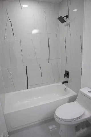 Full bath with tub / shower combination and tile patterned flooring