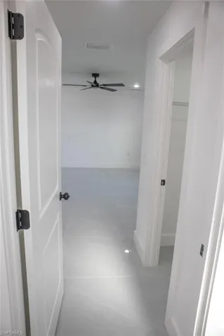 Hallway with light tile patterned floors and baseboards