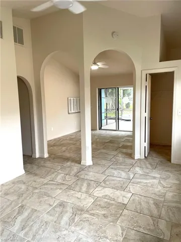 Unfurnished room with a high ceiling and ceiling fan
