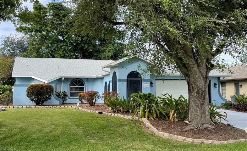 Ranch-style home with a front yard and a garage