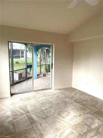 Empty room featuring vaulted ceiling