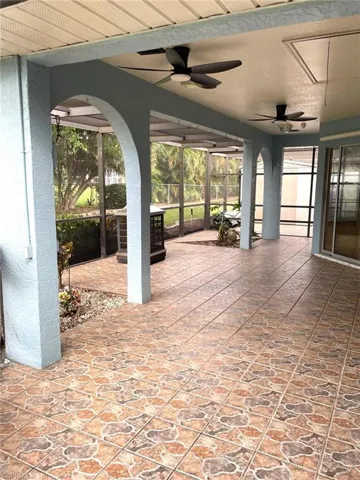 View of patio with ceiling fan and a lanai