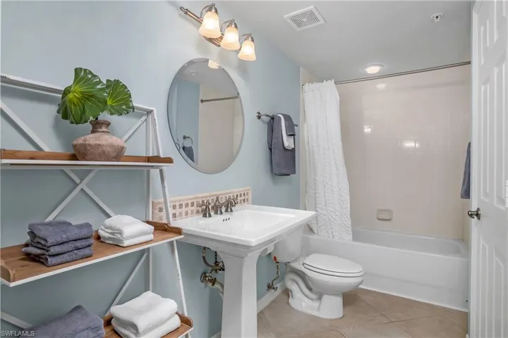 Bathroom featuring tile patterned flooring, toilet, and shower / bath combo