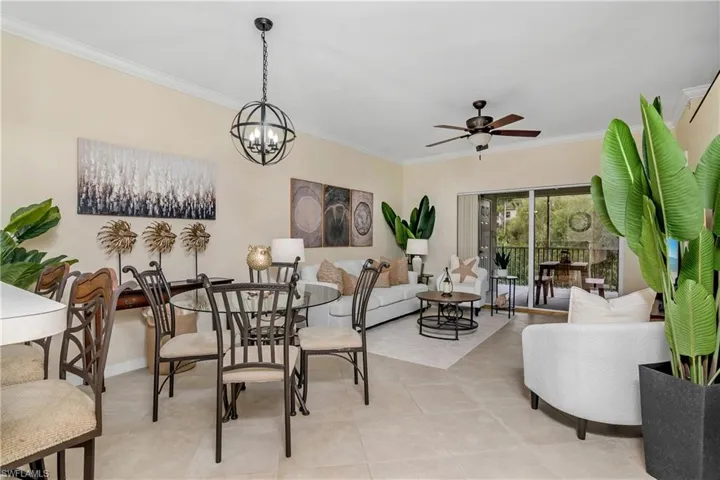Tiled dining area featuring ceiling fan with notable chandelier and ornamental molding