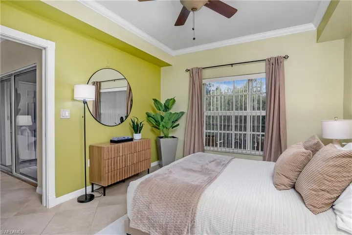 Tiled bedroom featuring crown molding and ceiling fan