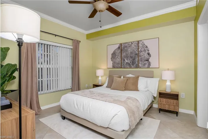 Tiled bedroom featuring crown molding and ceiling fan