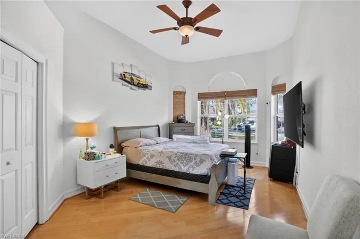 Bedroom with a ceiling fan, light wood finished floors, and a closet
