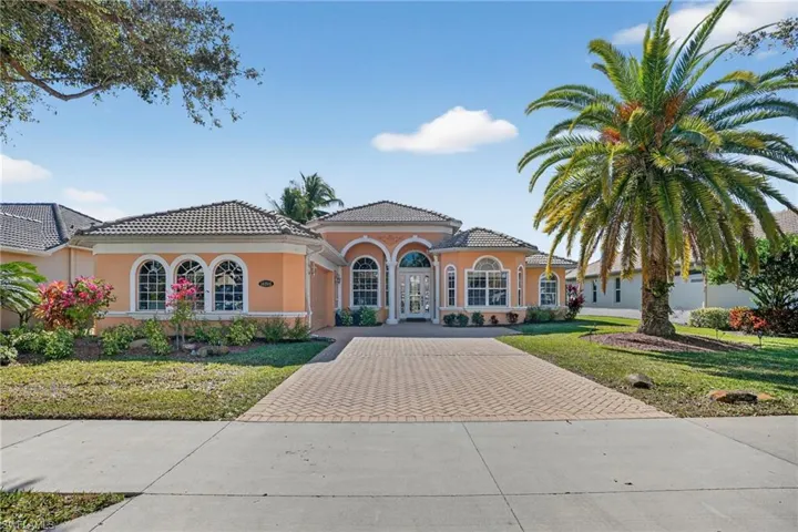 View of front of property featuring decorative driveway, stucco siding, a front yard, a garage, and a tiled roof